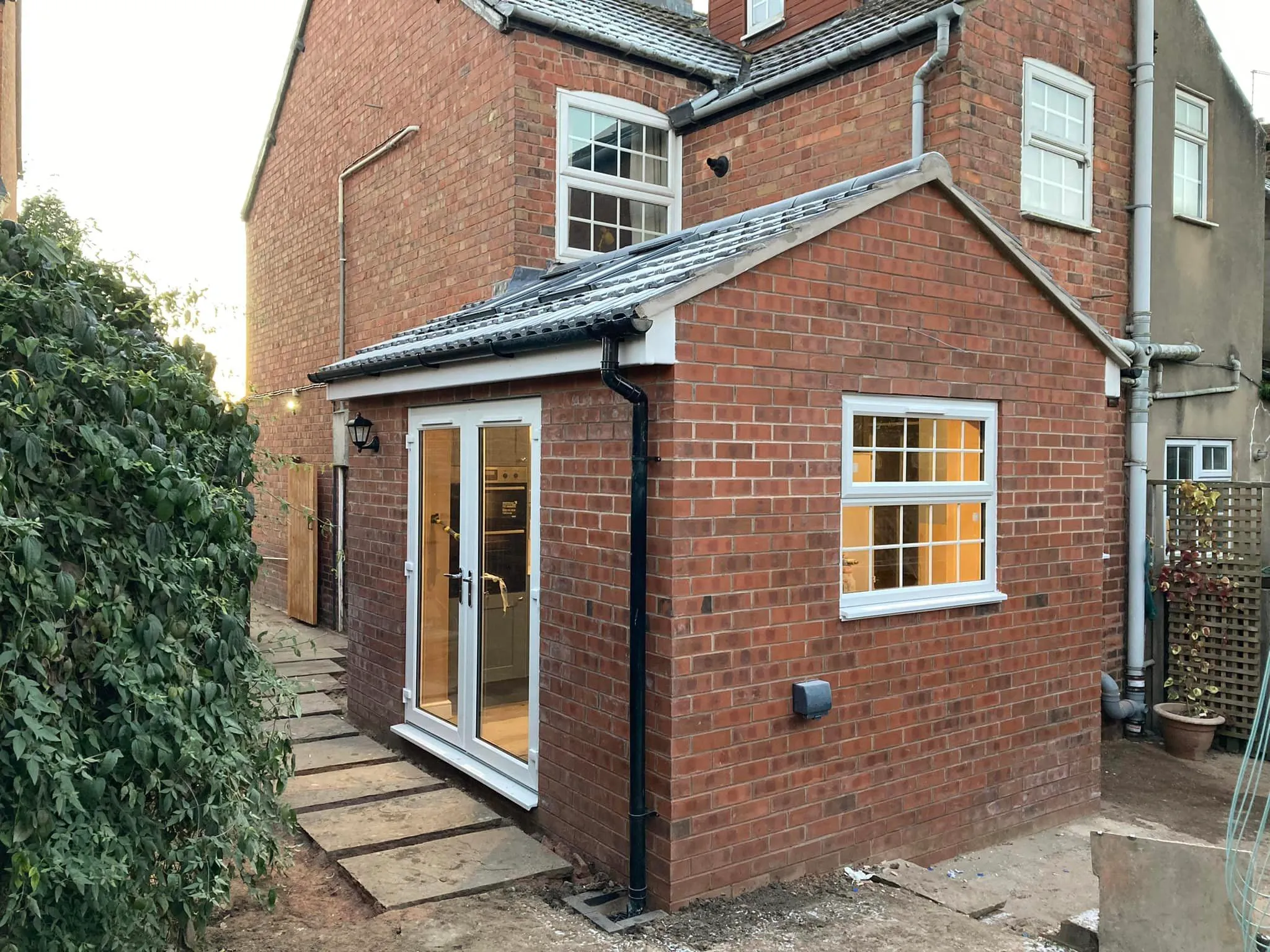 A brick house with a white door and windows.