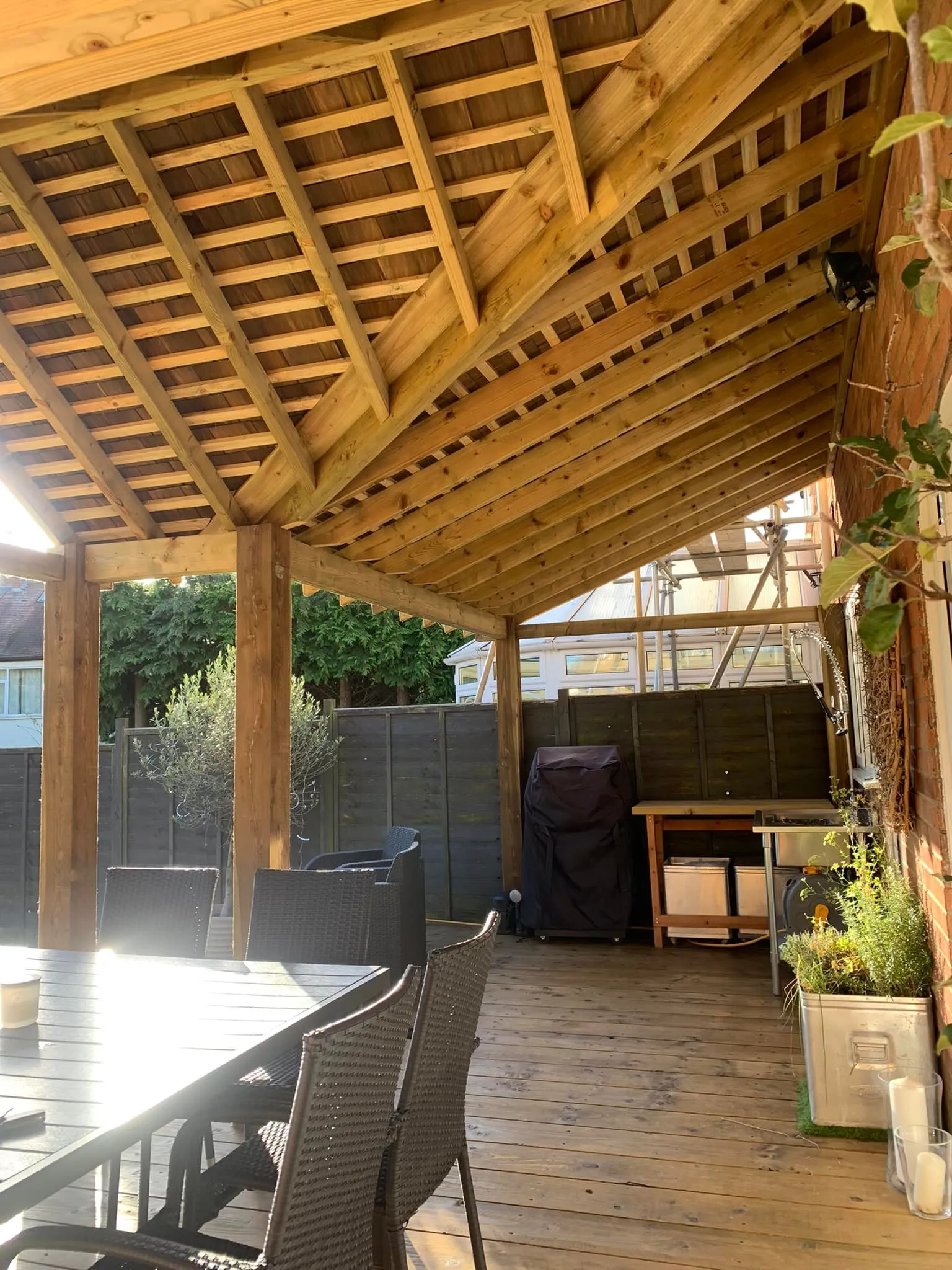 A covered patio with a table and chairs.