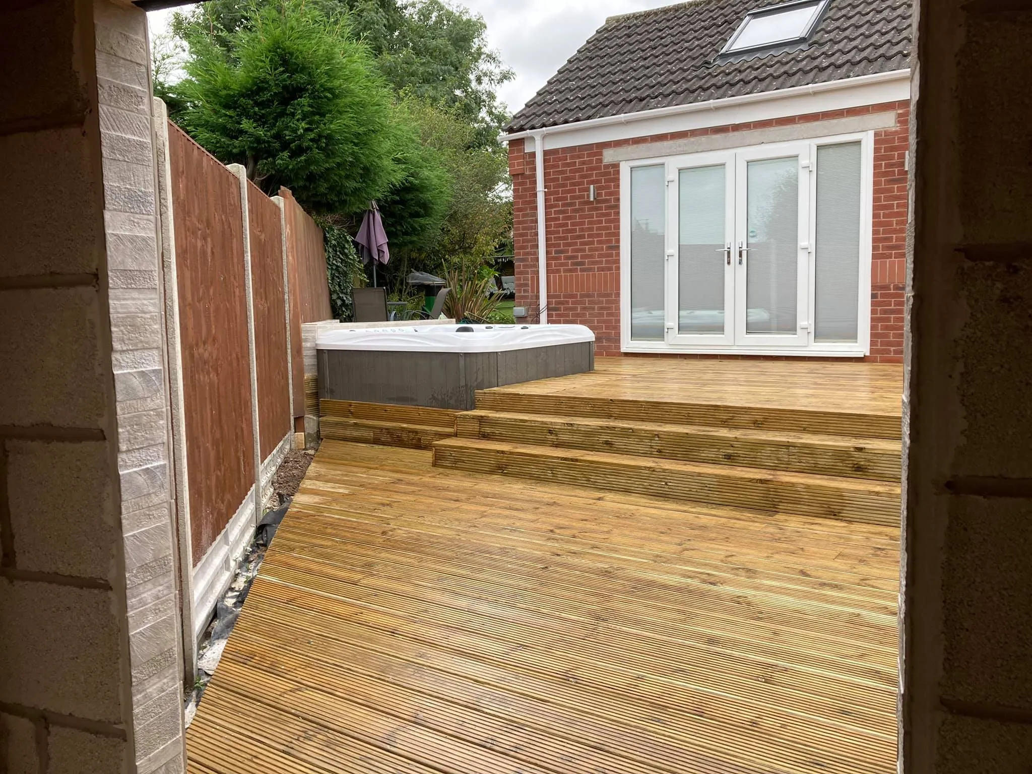 A hot tub sitting on top of a wooden deck.