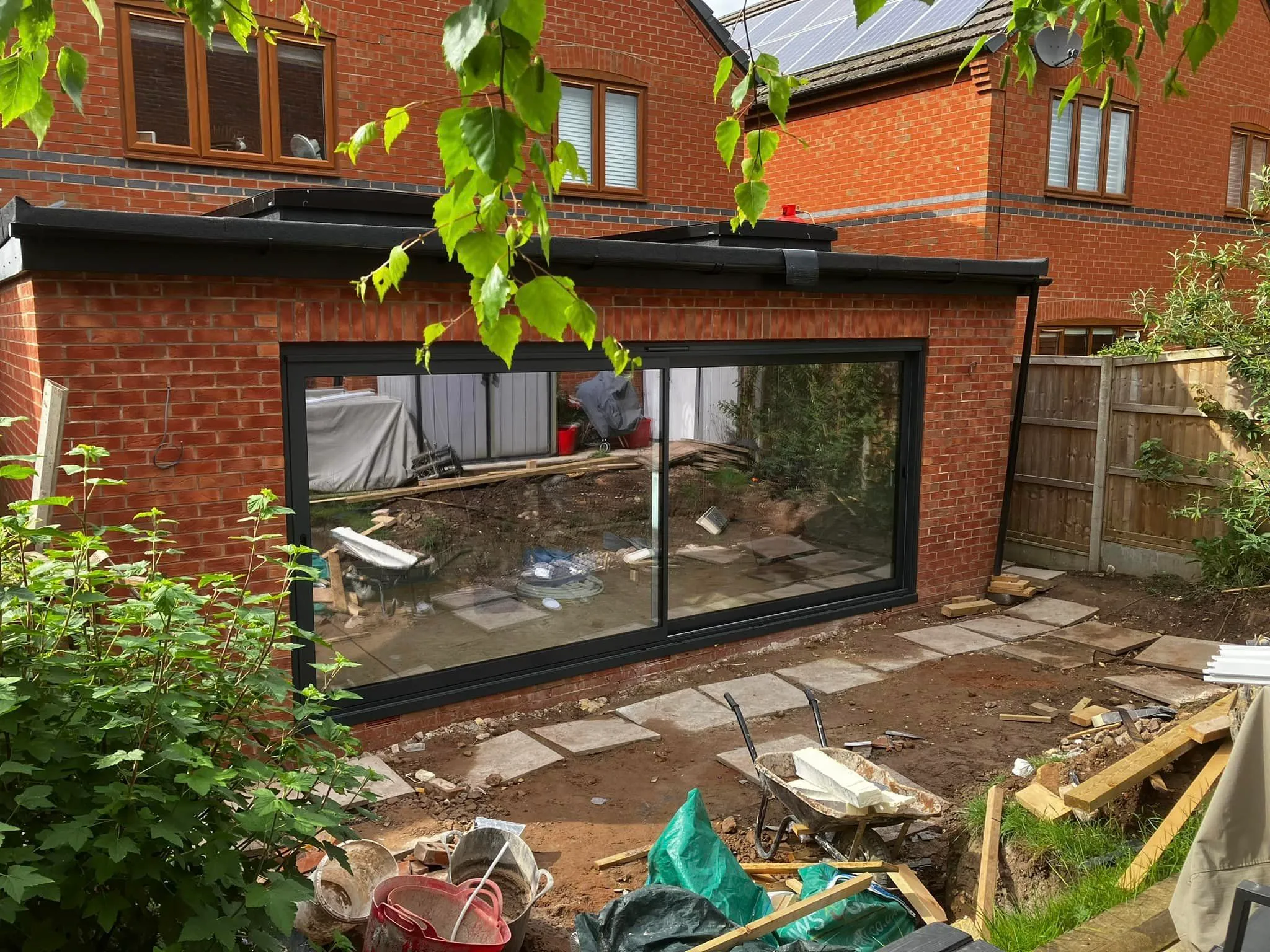 A back yard with a lot of junk and a building in the background.