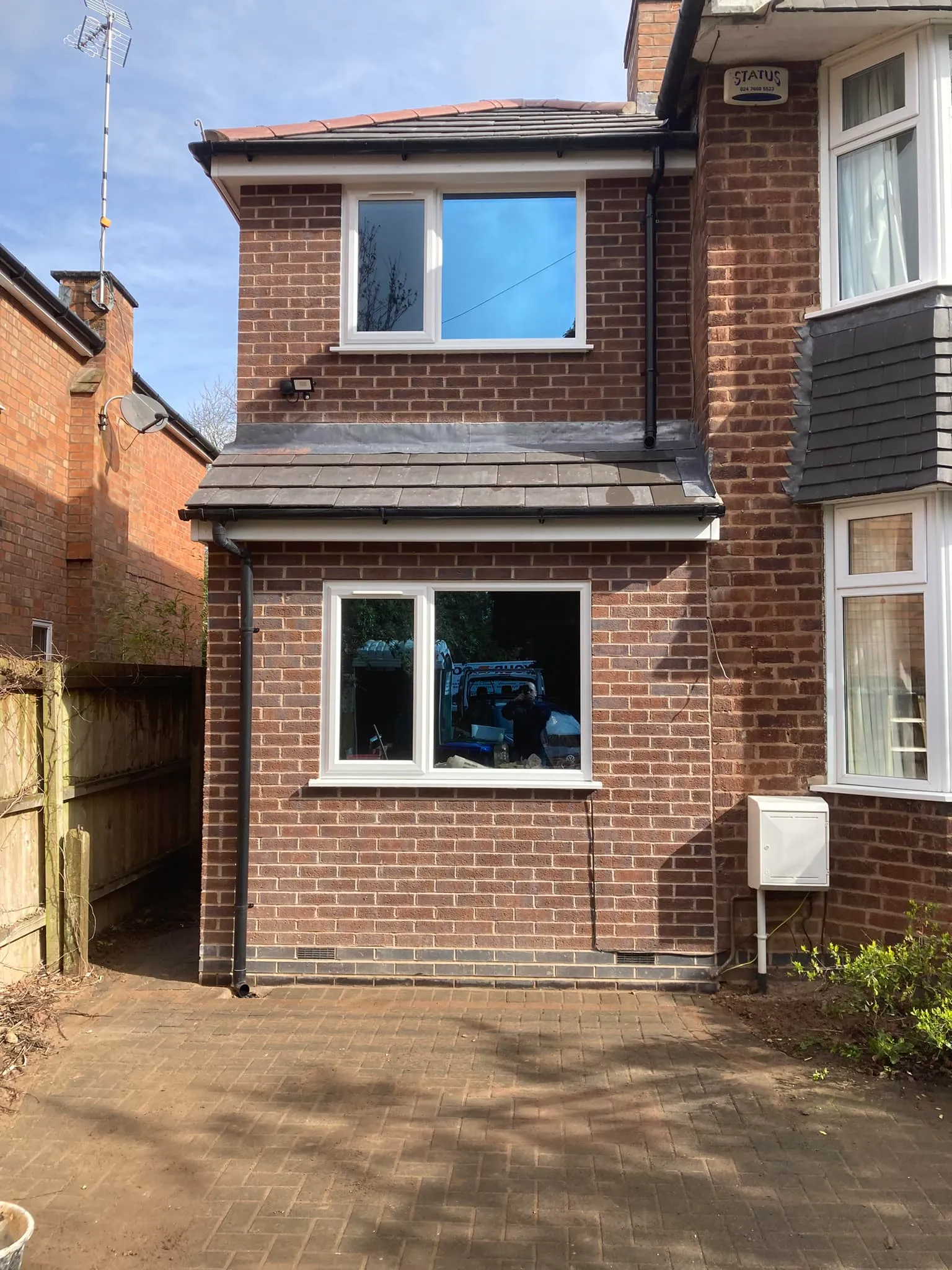 A brick house with a small car in the window.