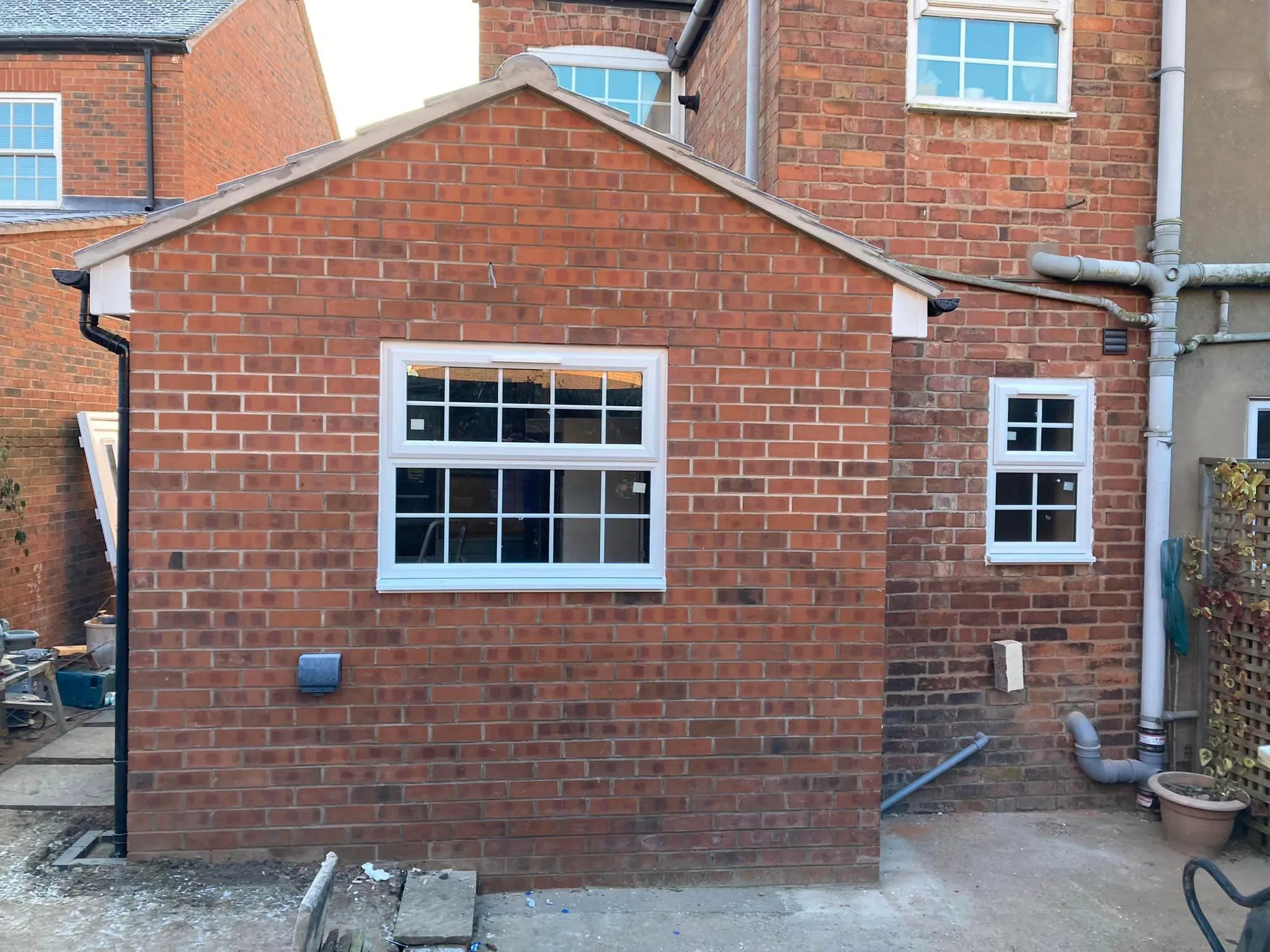 A red brick building with a white window.