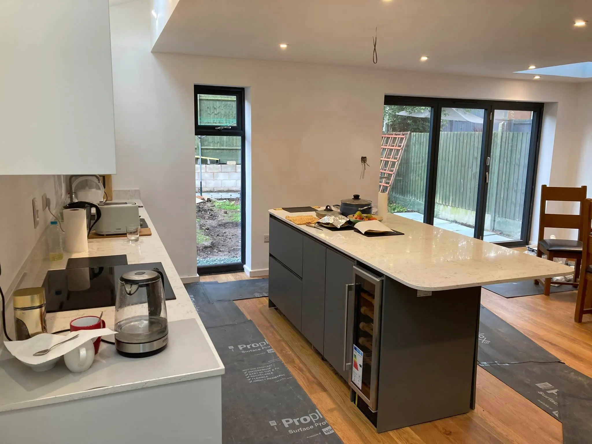 A kitchen with a stove, sink, and refrigerator.