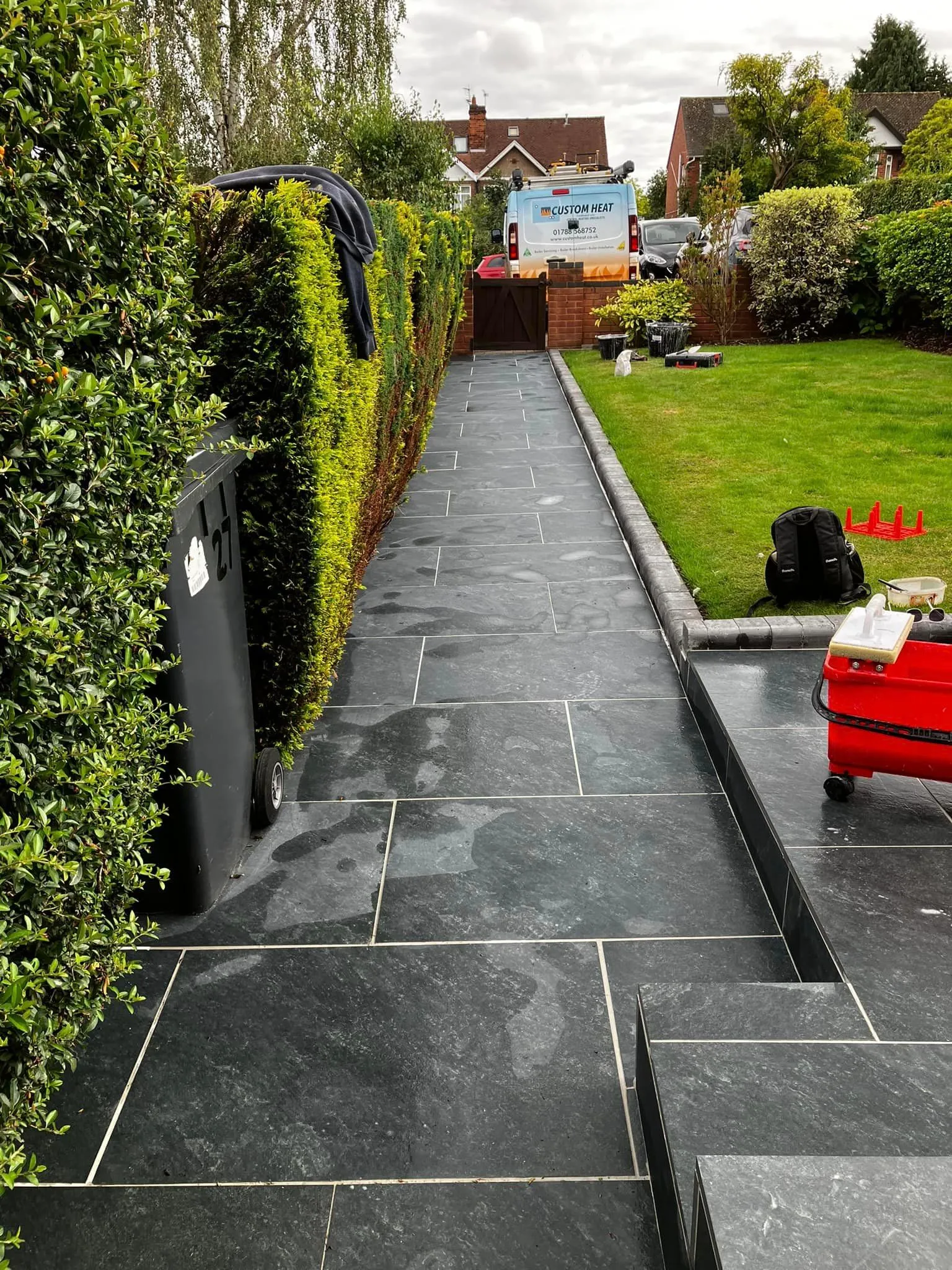 A long narrow walkway with a red chair in the middle of it.